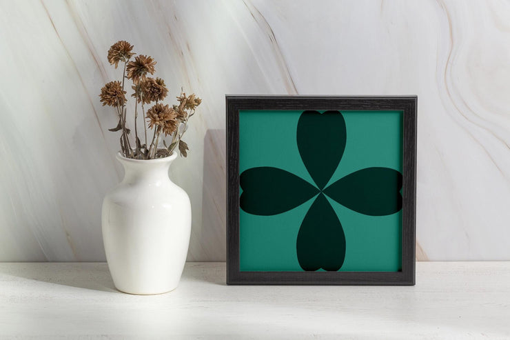 Framed Abstract Cloverleaf Wall Art on a shelf next to a vase of dried flowers