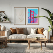 Golden Gate Bridge pink wall art displayed above a cozy living room sofa with natural decor